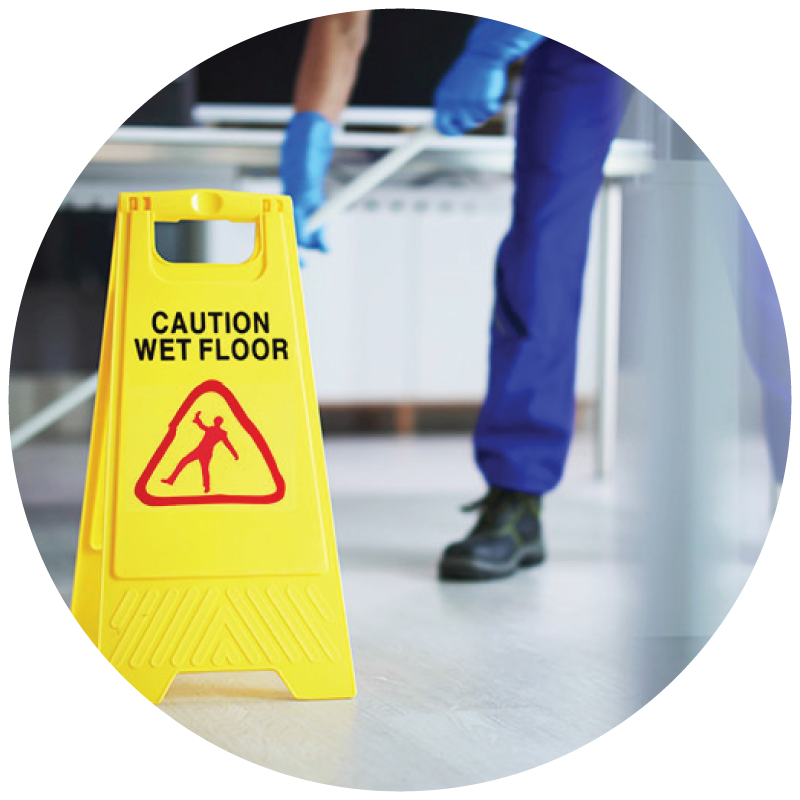 A custodian mopping the floor with wet floor caution sign on