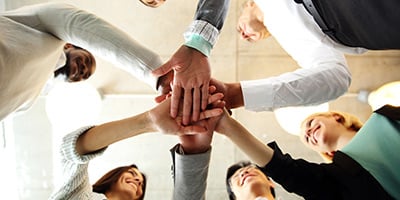 Business people putting their hands together for cheer