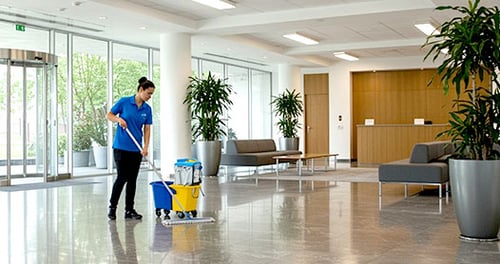 a facility staff wiping the office lobby floor