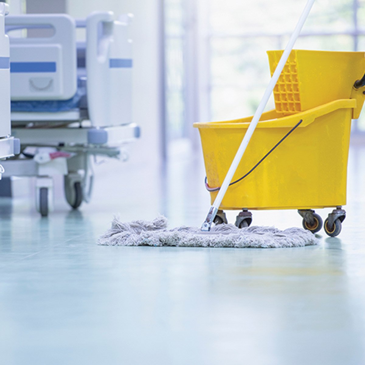 a cleaning cart with a mop on a hospital hallway floor