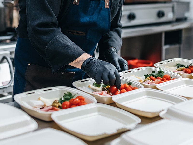 chef making deliver orders using disposable food containers