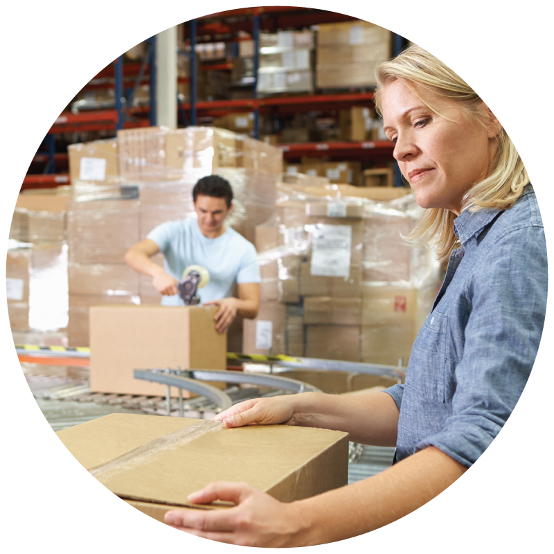 A female worker taping a box in a warehouse