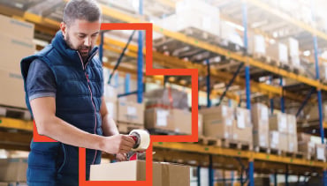 manually sealing shipping box in warehouse