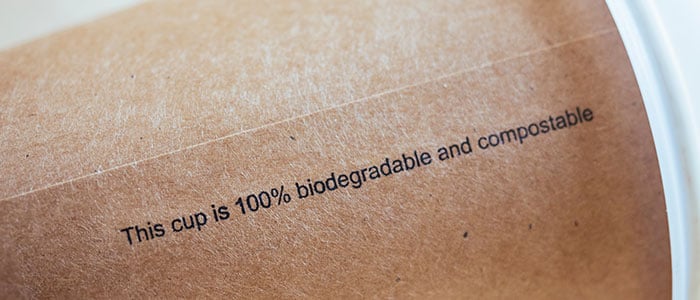 A disposable cup with biodegradable and compostable text on it