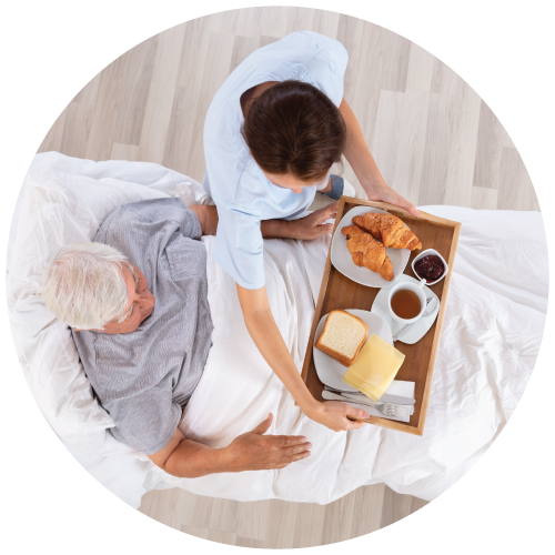 a caregiver seving meal to its resident in bed - nursing home