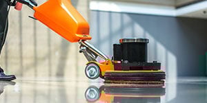 Floorcare - a person operating a floor scrubber