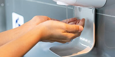 a person using hand sanitizer at the restroom