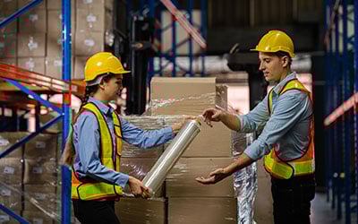 hand stretch film in used by two warehouse workers