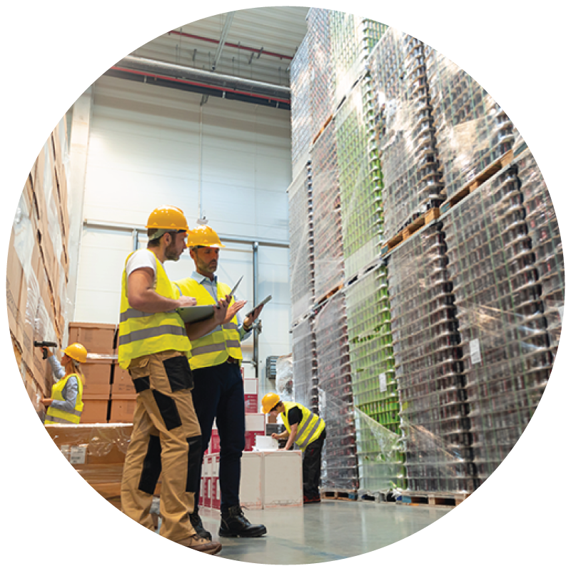 Warehouse workers looking at palletized shipments in a warehouse