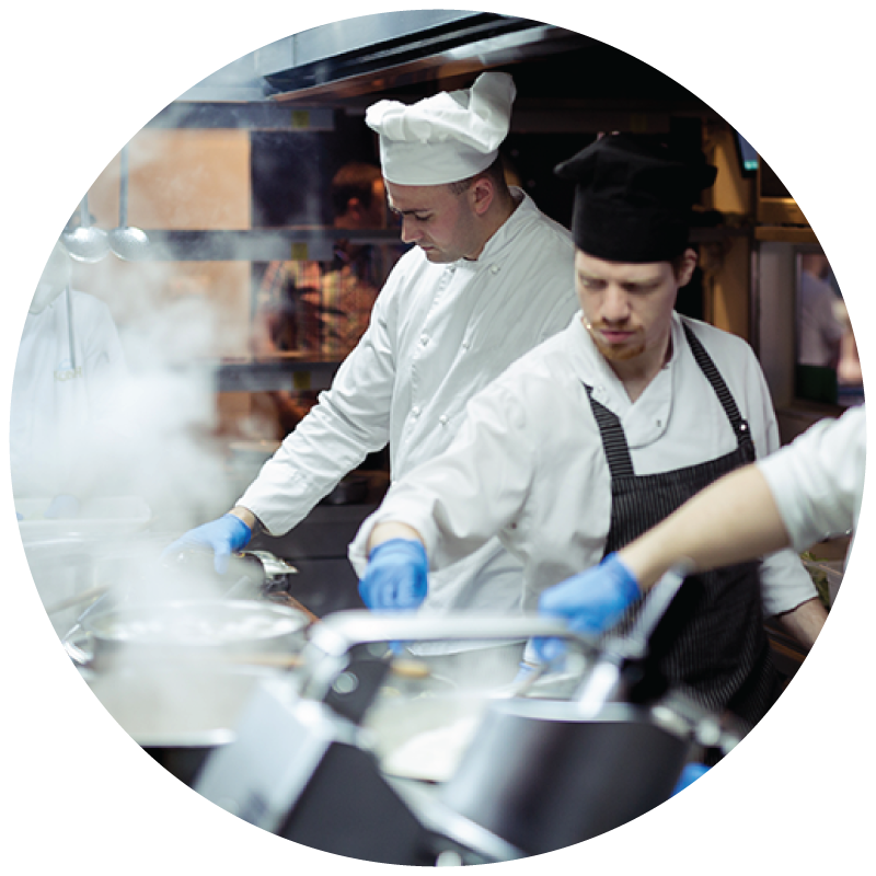 A few chefs cooking in a commercial foodservice kitchen