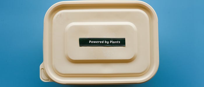 A disposable container with powered by plants text on it