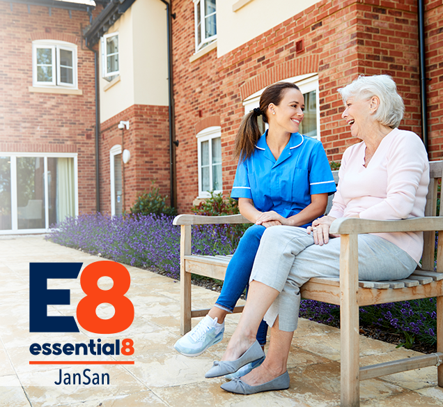 senior living facility occupant and nurse sitting on a bench making conversation