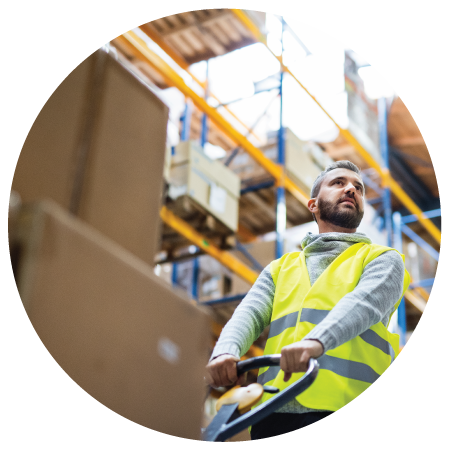A warehouse worker pulling boxes of shipment in his flatbed
