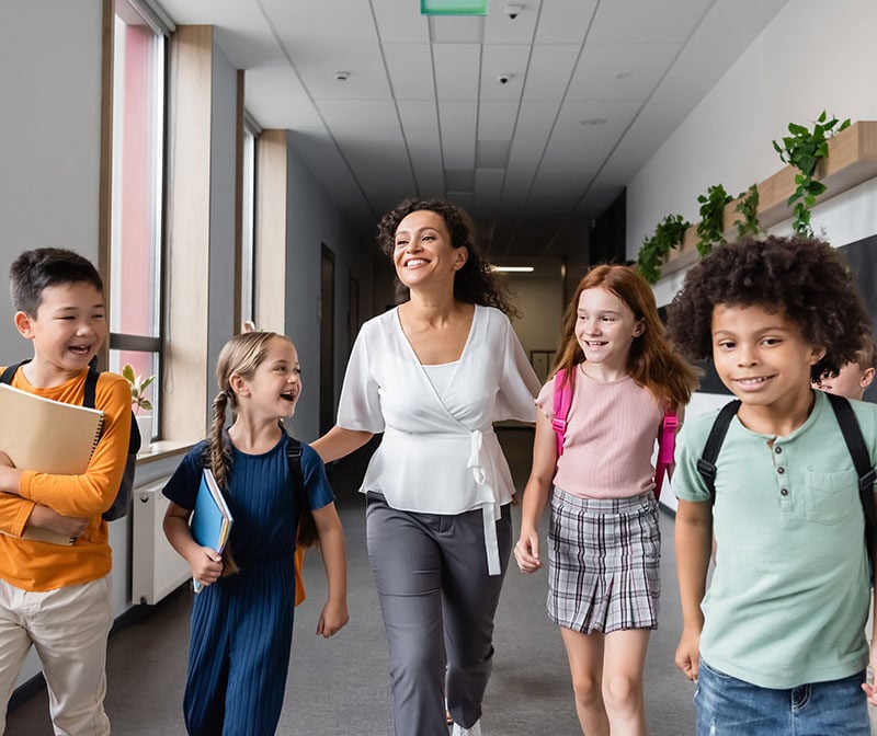a teacher and students walking down the hallway K-12
