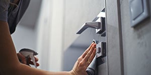housekeeping disinfecting door and doorknobs at the hotel