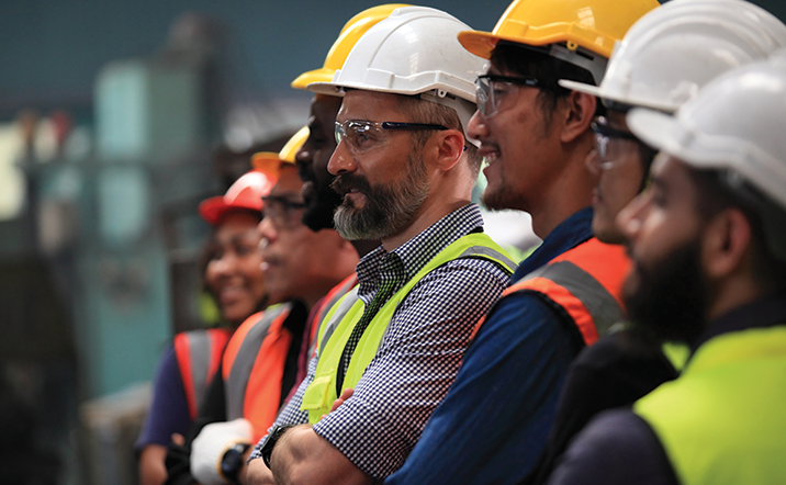 A group of engineers and packaging machine operators getting trained in wearing personal protective equipment