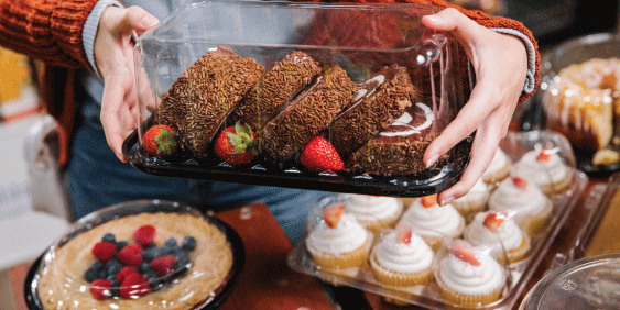 woman picking up baked goods in grocery store bakery