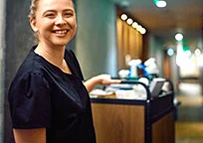 a housekeeping staff pulling housekeeping cart in a hotel