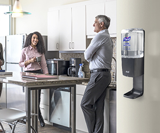 PUREL ES10 hand sanitizer mounted on the wall in the office kitchen with people socializing