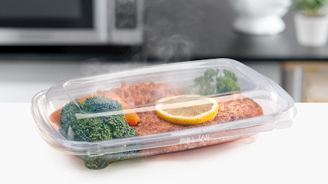 A clear Inline Plastics food container with hot food in it and steam coming out
