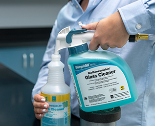 a facility manager pouring Spartan glass cleaner into a spray bottle using easy pouring dispenser